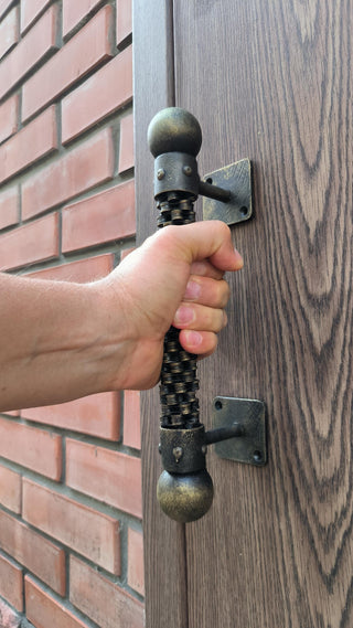A handmade industrial door handle made from a repurposed bicycle chain, featuring a rugged, steampunk design. Ideal for rustic and modern decor, this metal door pull adds a unique, durable touch to any door.