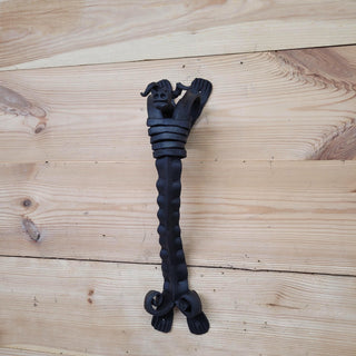 Decorative scene with a rustic iron bull head handle featured on a cabin door, styled in a woodland or Viking theme.