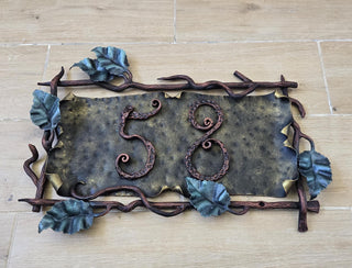 Full plaque displayed outdoors, mounted on light stone wall.