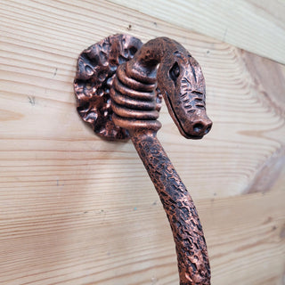 Hand-forged wrought iron snake door handle with antique copper finish, perfect for medieval and fantasy-themed doors.