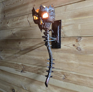 Angle view of horror-themed skull wall sconce on wooden background