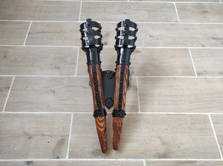 The metal shield has two light colored wooden handles with a beautiful texture and metal torch tops painted black. For indoor use only. Two bases for E27 bulbs. Imitate real antique torches. Suitable for USA, Europe, and Australia electrical
voltage.