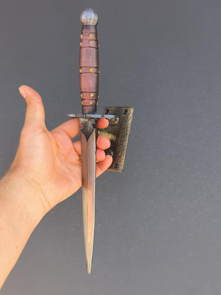 Door handle in the form of a dagger, realistically repeats the shape of a dagger - has a silver blade and copper-colored handle. Made of wrought iron.