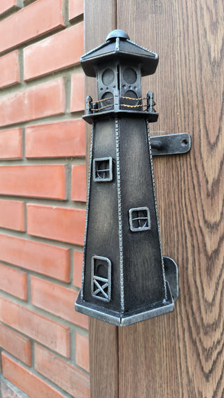 A vintage-style metal lighthouse door handle in a nautical theme, perfect for rustic and coastal home decor. Ideal for beach houses or cabins, this durable handmade door pull adds charm and function to any door.