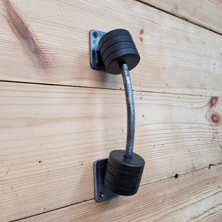 Metal door handle in the shape of a weightlifting barbell. Made by hand forging. Looks very realistic.