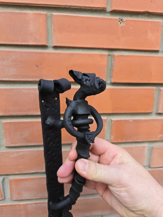 Close-up of blacksmith-made dog door handle from wrought iron.