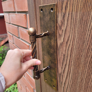 Heavy-duty iron door handle set in vintage style with brass patina, weather-resistant for outdoor use.