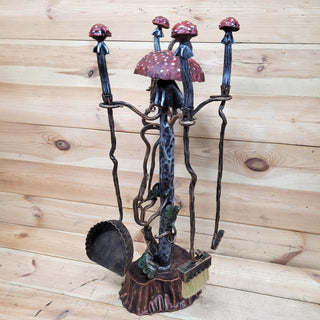 Hand-forged wrought iron fireplace tool set with red mushroom-shaped handles.