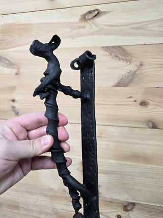 Side angle of decorative dog handle showing curled backplate design.