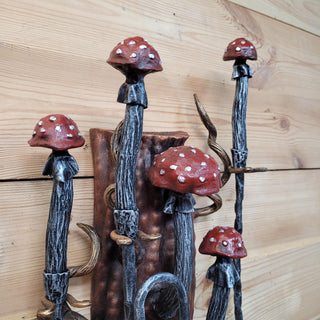 Close-up view of fantasy-style fire tools set with toadstool tops