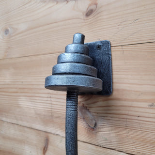 Hand-forged iron dumbbell door handle with rustic industrial design, perfect for gym-inspired decor.