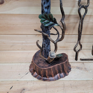 Base of the fireplace tool holder shaped like a tree trunk with oak leaf details.